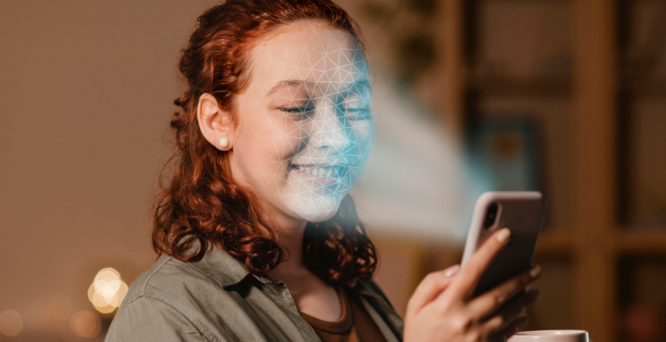 Meisje met rood haar kijkt naar haar telefoon terwijl het licht op haar gezicht schijnt